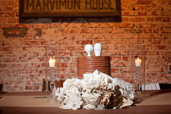 Chocolate multi-layered wedding cake with tan linen floral decor - photo by Orange County based wedding photographers Mark Brooke